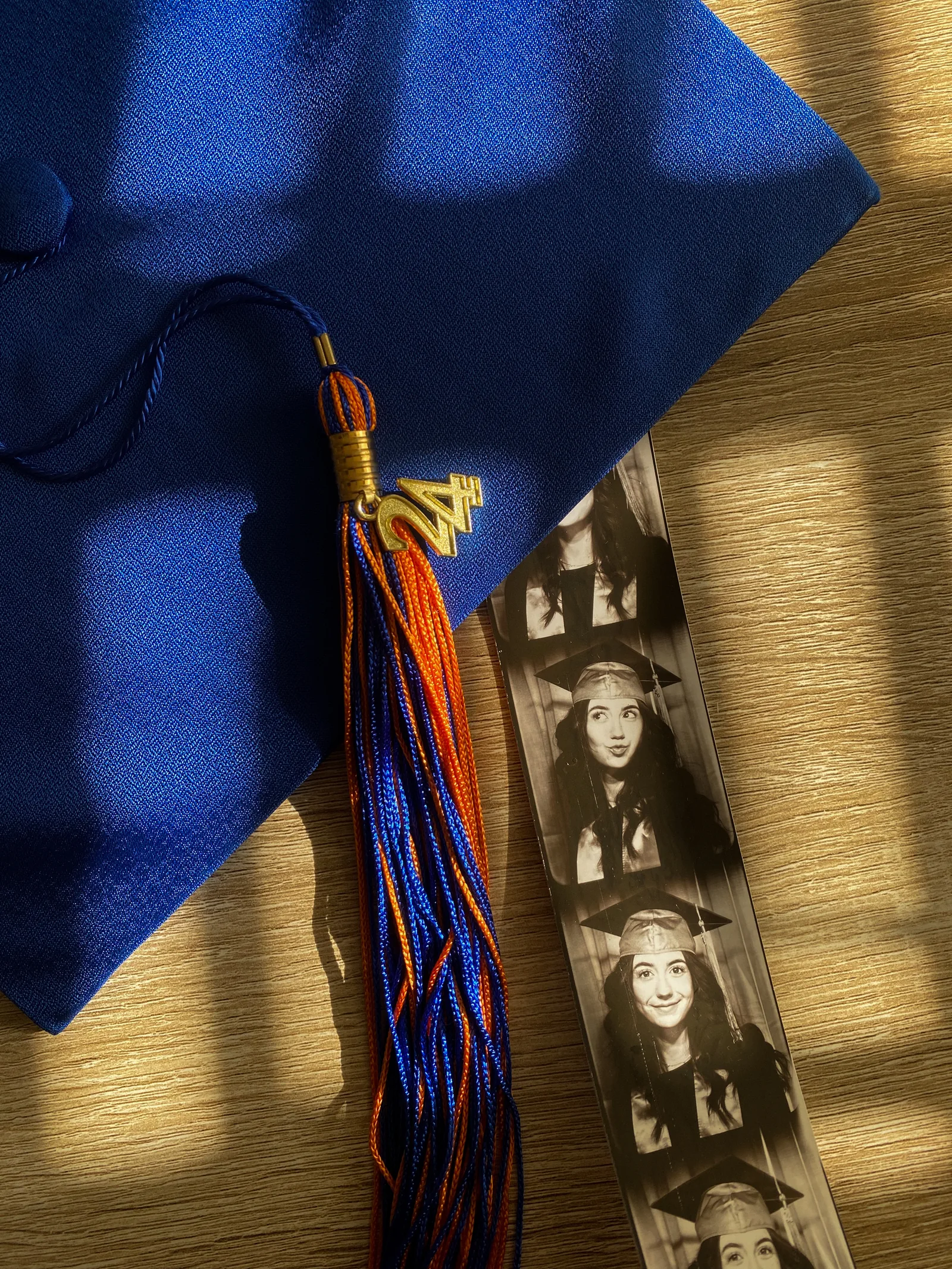 A graduation cap beside a small photo strip