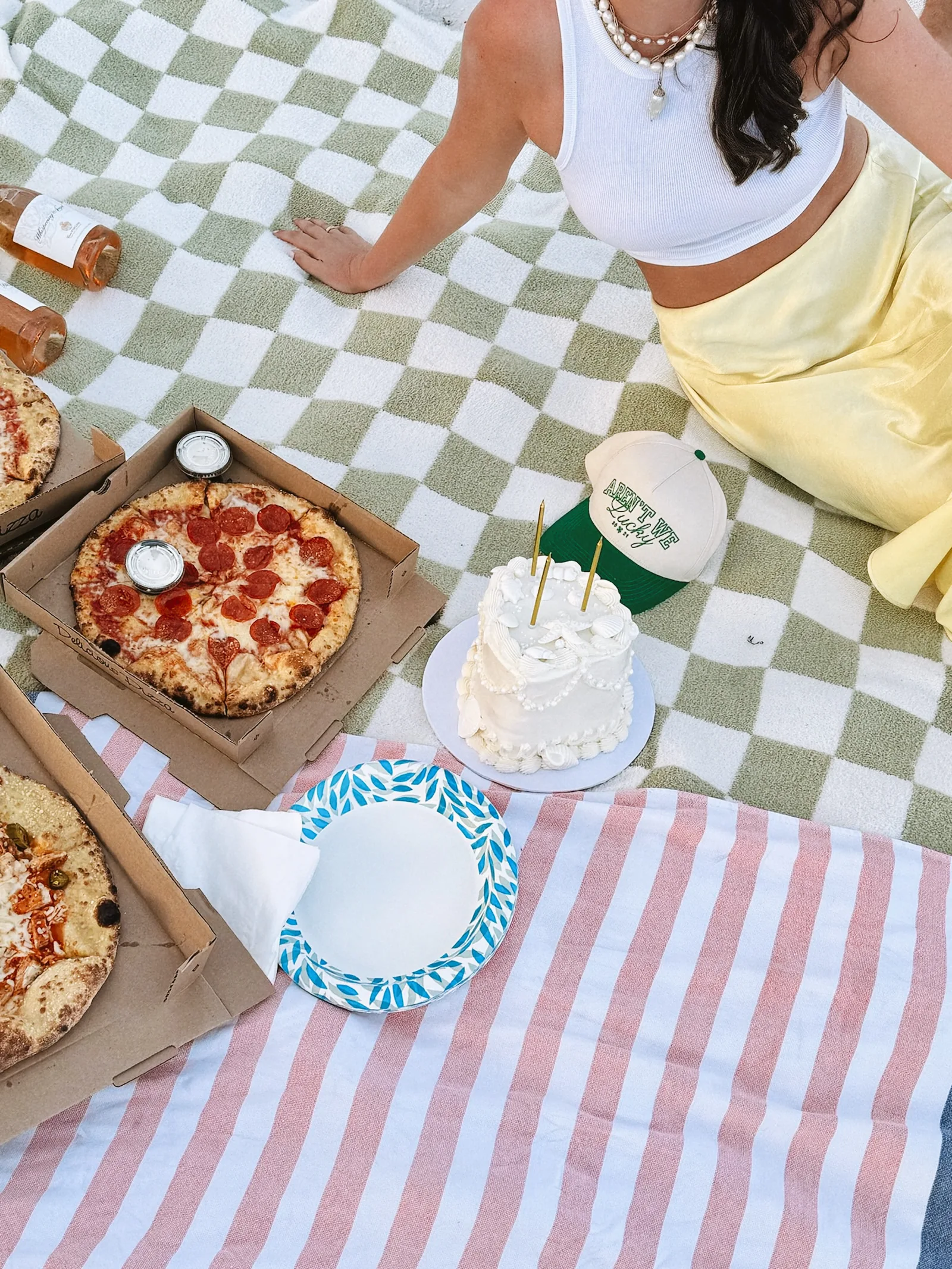 A picnic with pizza and a small birthday cake